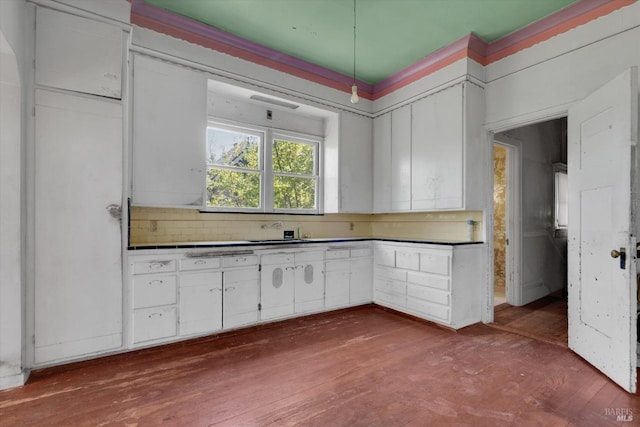 kitchen featuring decorative backsplash, hardwood / wood-style floors, and white cabinets