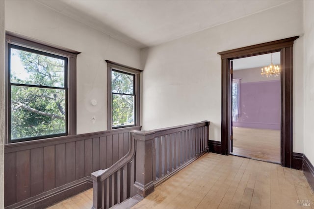 corridor featuring an inviting chandelier and light wood-type flooring