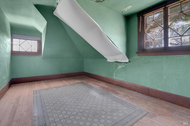 bonus room with vaulted ceiling and hardwood / wood-style flooring