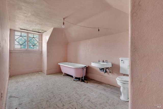 bathroom featuring sink, vaulted ceiling, and toilet