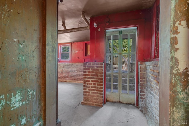 interior space featuring brick wall and concrete floors