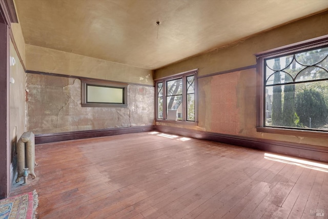 unfurnished living room with a wealth of natural light and hardwood / wood-style flooring