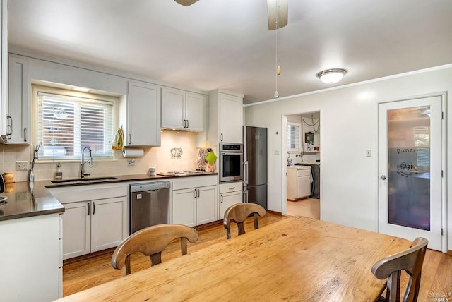 kitchen featuring stainless steel appliances, sink, white cabinets, and backsplash