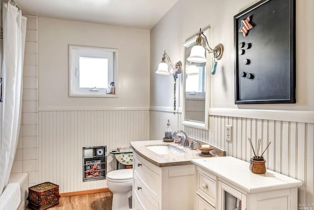 full bathroom featuring vanity, wood-type flooring, shower / bathtub combination with curtain, and toilet