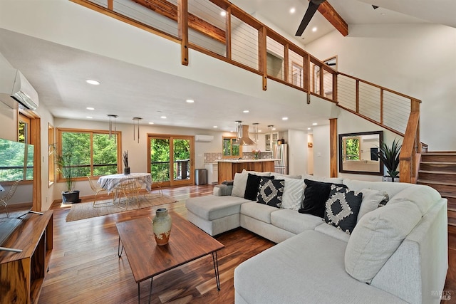 living room with dark hardwood / wood-style flooring, a wall mounted air conditioner, beamed ceiling, and a high ceiling