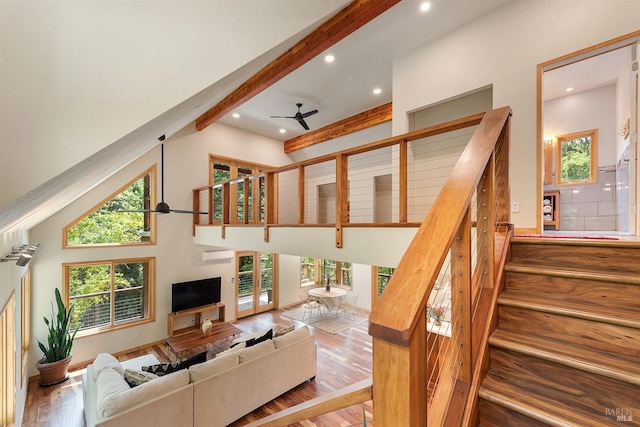 living room featuring hardwood / wood-style flooring, ceiling fan, beam ceiling, and high vaulted ceiling