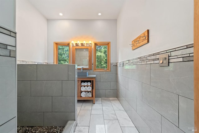 bathroom featuring vanity, a shower, and tile walls