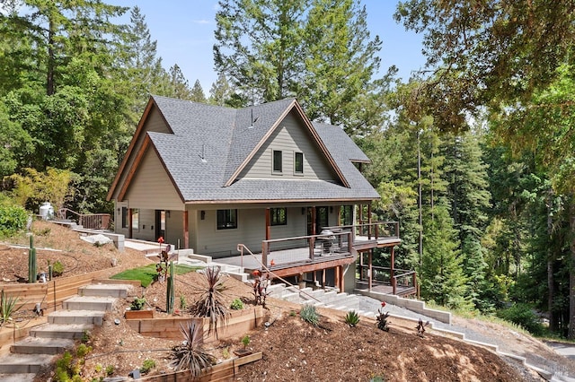 view of front facade featuring a wooden deck and a patio