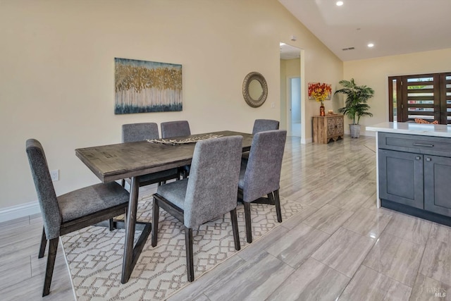 dining area featuring light hardwood / wood-style floors and lofted ceiling