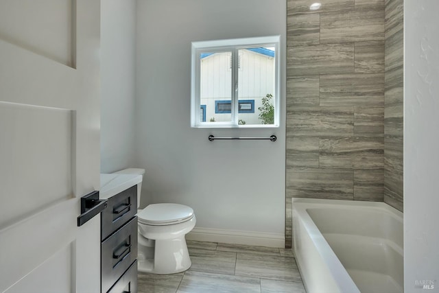 bathroom with a washtub, toilet, and vanity