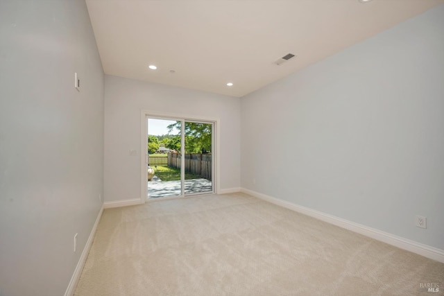 spare room featuring light carpet