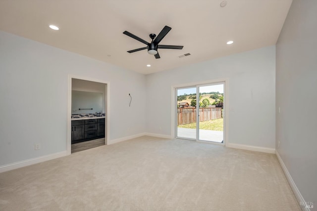 spare room featuring light colored carpet and ceiling fan