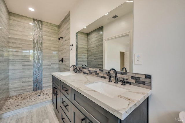 bathroom featuring a tile shower and vanity