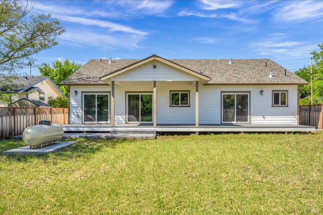 rear view of house featuring a lawn and a wooden deck