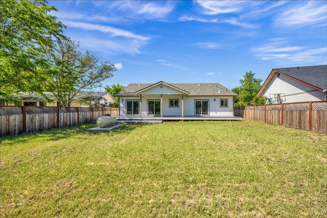 back of property featuring a deck and a lawn