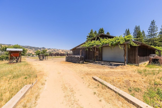 view of home's exterior featuring a mountain view and an outbuilding