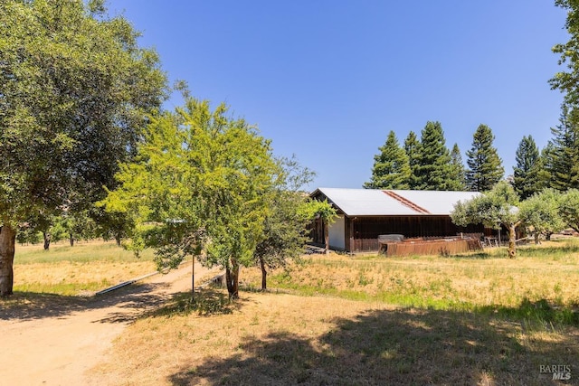 view of yard with an outbuilding and a rural view