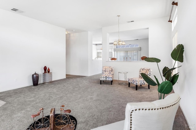 carpeted living room featuring a notable chandelier