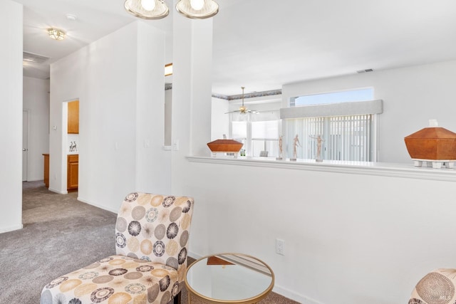 living area featuring carpet floors and ceiling fan