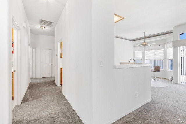 corridor featuring carpet flooring, visible vents, and baseboards