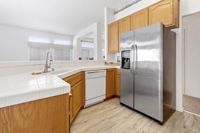 kitchen with dishwasher, light wood-type flooring, stainless steel refrigerator with ice dispenser, and tile counters