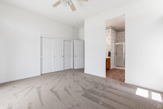 unfurnished bedroom featuring light colored carpet, ensuite bath, and ceiling fan