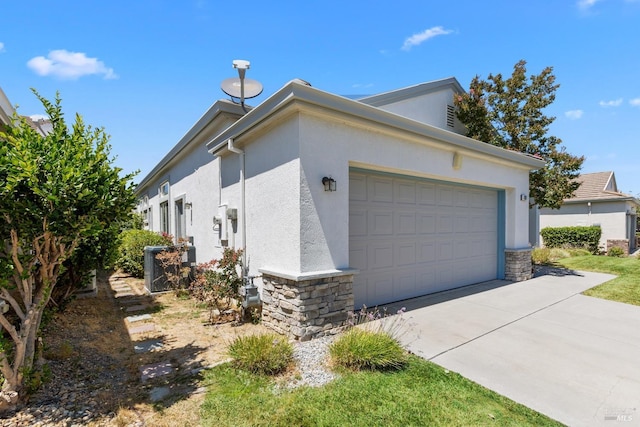 view of property exterior featuring a garage, stone siding, driveway, and stucco siding