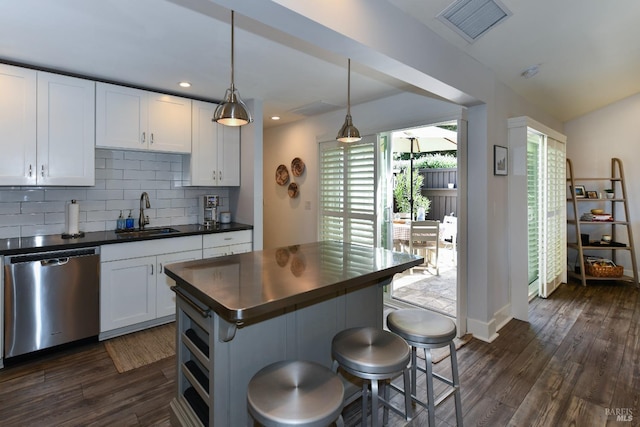 kitchen featuring white cabinets, sink, decorative light fixtures, dishwasher, and a center island