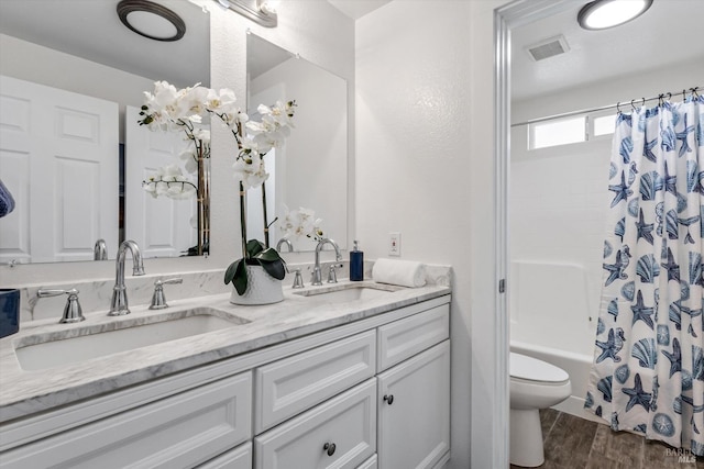 full bathroom with shower / tub combo with curtain, wood-type flooring, toilet, and vanity