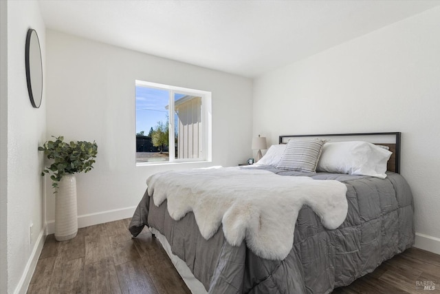 bedroom with dark hardwood / wood-style floors