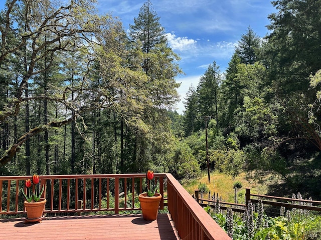 wooden terrace featuring a view of trees