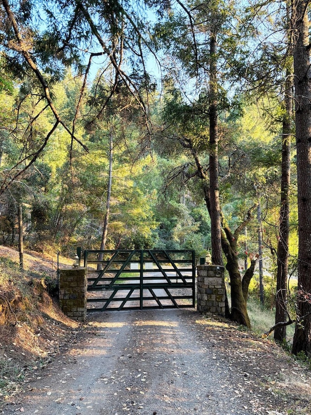 view of gate with a view of trees