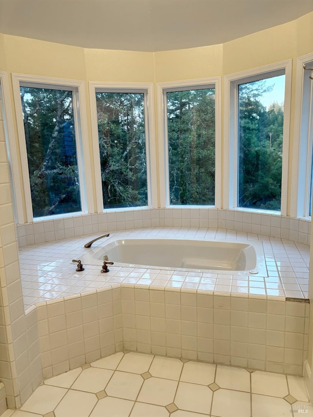 bathroom with tiled bath and tile patterned flooring