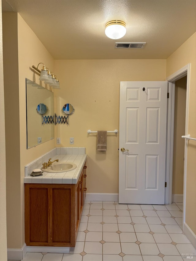 bathroom featuring vanity, a textured ceiling, and tile patterned flooring