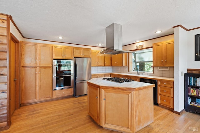 kitchen featuring tile countertops, light hardwood / wood-style floors, island exhaust hood, stainless steel appliances, and a center island