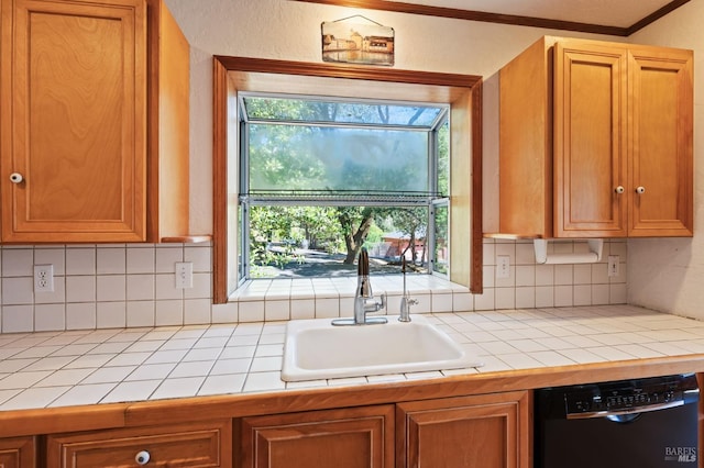 kitchen featuring tile countertops, decorative backsplash, dishwasher, ornamental molding, and sink