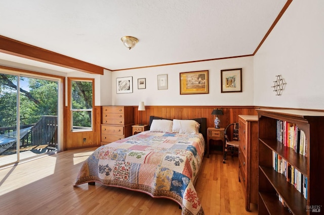 bedroom featuring ornamental molding, light hardwood / wood-style flooring, and access to outside