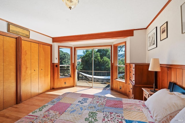 bedroom featuring access to exterior, a closet, crown molding, and light hardwood / wood-style flooring