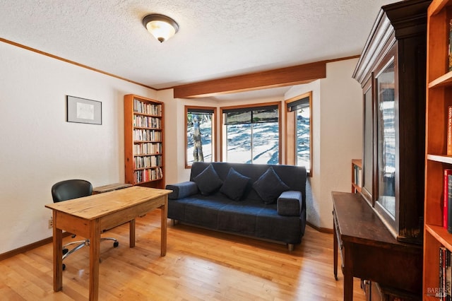 office area with a textured ceiling, crown molding, and light hardwood / wood-style flooring