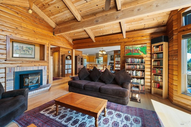 living room featuring a notable chandelier, beam ceiling, light hardwood / wood-style flooring, wood ceiling, and a wood stove