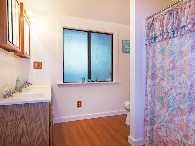 bathroom with hardwood / wood-style floors, vanity, and toilet