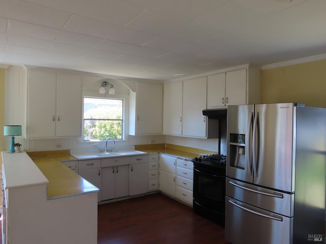 kitchen featuring stainless steel fridge, black gas range, white cabinetry, and sink