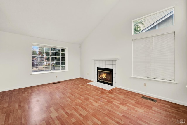 unfurnished living room with a fireplace, hardwood / wood-style flooring, and high vaulted ceiling