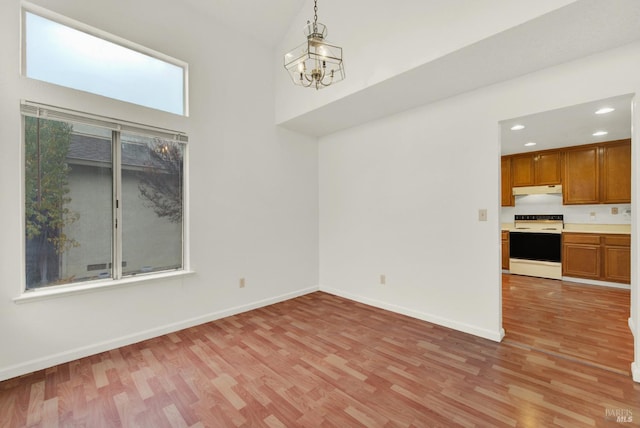 unfurnished dining area featuring light hardwood / wood-style floors and a chandelier