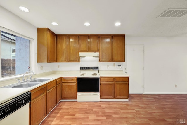 kitchen featuring light wood-type flooring, white appliances, and sink