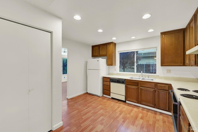 kitchen featuring white appliances, light hardwood / wood-style flooring, and sink