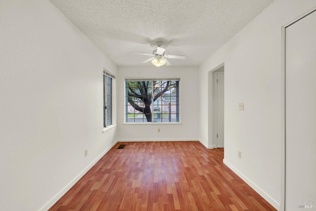 unfurnished room featuring ceiling fan, a textured ceiling, and light hardwood / wood-style flooring