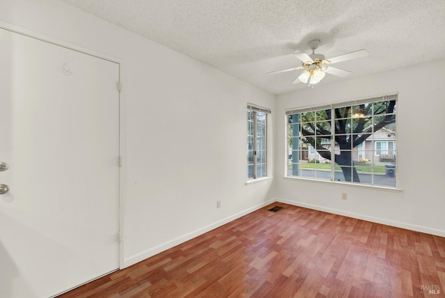 interior space with ceiling fan, wood-type flooring, and a textured ceiling