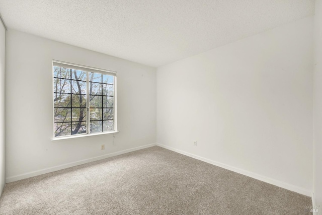 carpeted empty room with a textured ceiling