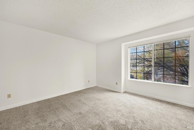 carpeted spare room with a textured ceiling